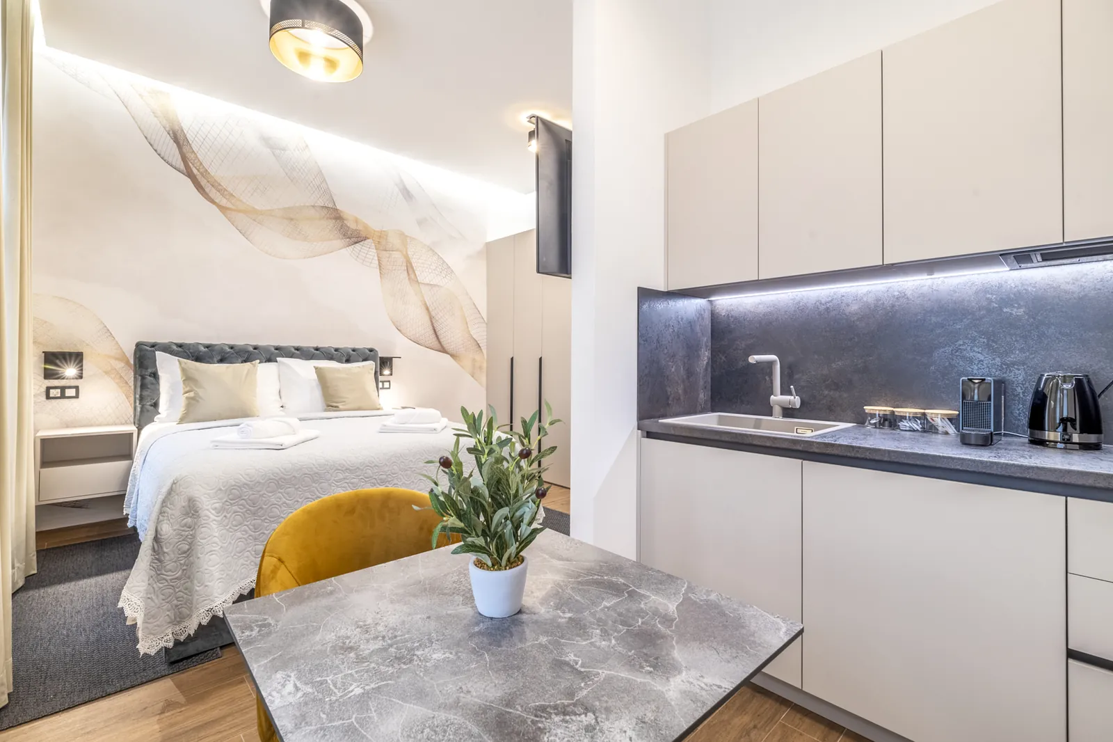Monolocale: Cucina, letto e tavolo in marmo nello stesso spazio